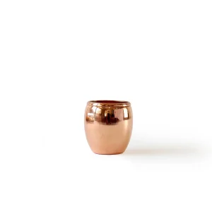 Handcrafted copper shot glass with smooth, seamless finish Copper shot glass filled with chilled vodka Copper shot glass filled with chocolate mousse Copper shot glass filled with mini fruit salad Copper shot glasses arranged on a bar cart